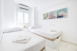 a white room with two beds and a sink at Torre Yago Deluxe 1-2 Levante Beach in Benidorm