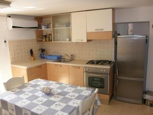a kitchen with a stainless steel refrigerator and a table at Apartment Haramina in Baška