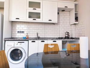 biała kuchnia z pralką w obiekcie Denizolgun Homes Suit Apart 2 w mieście Dalaman