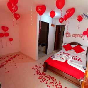 een slaapkamer met een bed met rode ballonnen aan de muur bij Hotel la Victoria in San Roque