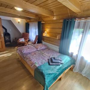 ein Schlafzimmer mit einem Bett und einem Stuhl in einem Zimmer in der Unterkunft Domek pod Brzozami - zniżki na Termy Bania! in Czarna Góra