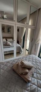 Christinas home A place to go to في Saronida: غرفة نوم مع سرير مع مرآة كبيرة