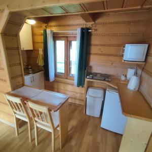 a small kitchen with a table and a desk in a tiny house at Domek pod Brzozami - zniżki na Termy Bania! in Czarna Góra