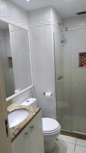 a bathroom with a toilet and a glass shower at Bora Bora Barra Resort in Rio de Janeiro