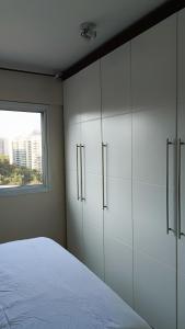 a bedroom with white cabinets and a window at Bora Bora Barra Resort in Rio de Janeiro