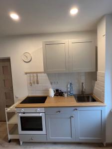 a kitchen with white cabinets and a sink at London Apartments in Katowice