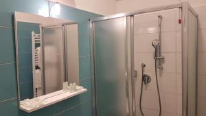 a bathroom with a shower and a mirror at Hotel Ristorante Il Gabbiano in Cecina