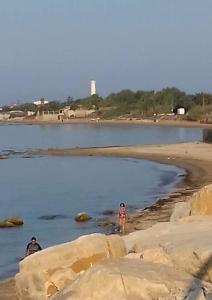 dos personas caminando por la playa cerca del agua en MaryAlex en Punta Secca