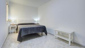 a white bedroom with a bed and a table at Puerto Centro in Puerto del Rosario