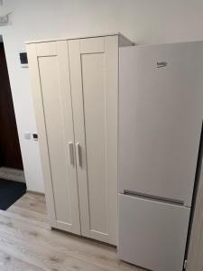a kitchen with a white cabinet and a refrigerator at London Apartments - Free parking in Katowice