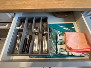 bandeja con utensilios de plata en un cajón en London Apartments, en Katowice