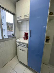 a kitchen with a red appliance on a counter at Ap aconchegante 12 min a pé p Praia in Praia Grande