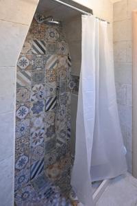 een douche met een douchegordijn in de badkamer bij Casa vacanze nonna donata in Martina Franca +3 foto's