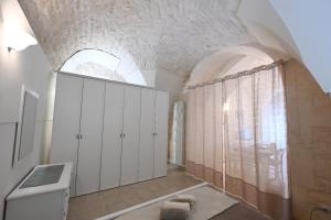 een badkamer met witte kasten en een groot raam bij Casa vacanze nonna donata in Martina Franca