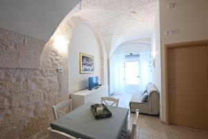 een eetkamer met een tafel en een woonkamer bij Casa vacanze nonna donata in Martina Franca