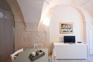 een woonkamer met een tafel en een tv bij Casa vacanze nonna donata in Martina Franca