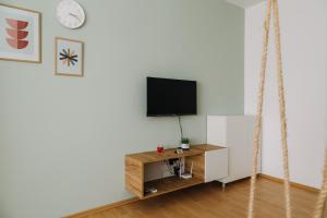 a living room with a tv on a wall at Constantin Inn in Niš