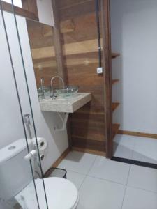 ein Bad mit einem Waschbecken und einem WC in der Unterkunft Hostel Amicum in Massarandupio