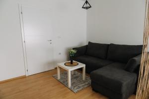 sala de estar con sofá negro y mesa en Constantin Inn en Niš