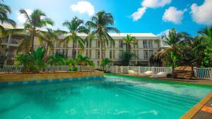 una piscina frente a un edificio con palmeras en On Vacation Blue Cove, en San Andrés
