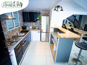 a kitchen with a refrigerator and a stove top oven at Villa Baies Roses - Piscine chauffée Ile de la Réunion in Le Tampon