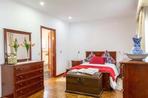 Schlafzimmer mit einem Bett, einer Kommode und einem Spiegel in der Unterkunft Quinta da Laceira - Douro Valley - Alojamento Local in Vila Real