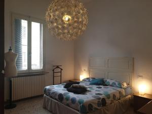 a bedroom with a large bed and a chandelier at Cleo Tulipano in Falconara Marittima