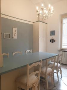 una sala da pranzo con tavolo e sedie blu di Cleo Tulipano a Falconara Marittima