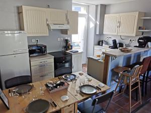 cocina con mesa de madera y encimera en Les Embruns Méloriens, en Saint-Méloir-des-Ondes