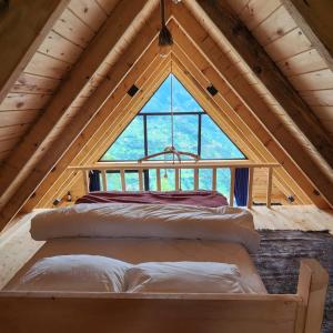 a bed in a attic with a large window at ONASUITBUNGALOW in Rize