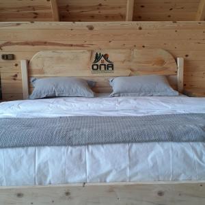 a bed in a wooden cabin with two pillows at ONASUITBUNGALOW in Rize