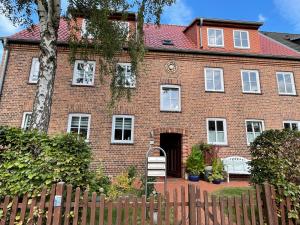 una casa de ladrillo con una valla delante de ella en große Wohnung zentral gelegen, en Neubrandenburg