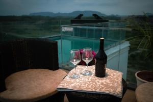 a bottle of wine and two glasses on a table at Amizunie's Boutique Hotel by SSAZ Hospitality in Udaipur