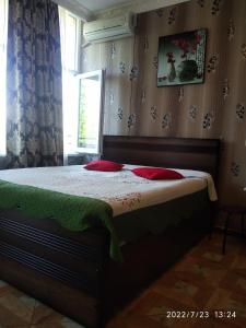 - une chambre avec un lit doté d'oreillers rouges et une fenêtre dans l'établissement Kobuleti Rezidense, à Kobuleti