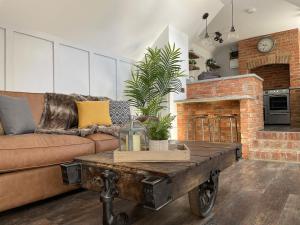 uma sala de estar com um sofá e uma lareira de tijolos em The Old Brewhouse & Piggery em Newport