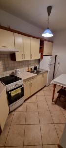 a kitchen with a stove and a refrigerator and a table at Przytulny - blisko centrum in Suwałki