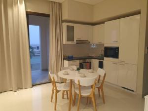 a kitchen and dining room with a table and chairs at Acacia Flower AC 8-201 in Salalah +6 photos