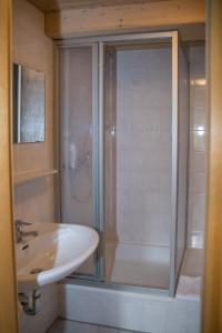 uma casa de banho com um chuveiro e um lavatório. em Hotel im Sonnental em Jachenau