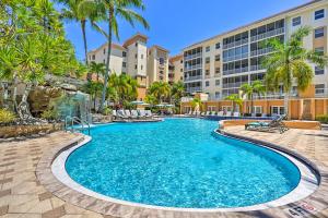 a pool at a resort with palm trees and buildings at Naples Escape in Regatta with Resort Amenities! in Naples