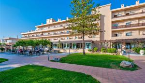 ein großes Gebäude mit einem Park davor in der Unterkunft Giannoulis – Santa Marina Beach Hotel in Agia Marina