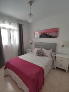 1 dormitorio con 1 cama con manta morada en Apartamento Lanzarote Volcano, en Puerto del Carmen