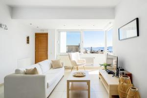 a living room with a white couch and a table at Mira Sitia Luxury Apartment in Sitia