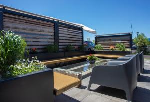 une terrasse avec une rangée de bancs et de plantes dans l'établissement Wingate by Wyndham Dieppe Moncton, à Moncton
