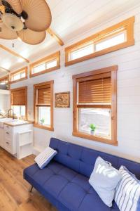 a living room with a blue couch and windows at Aloha Tiny Home in Apple Valley