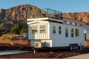 a tiny house with a balcony on top of it at Aloha Tiny Home in Apple Valley