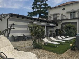 una fila de sillas y mesas blancas en un patio en B&B Villa Prestigio, en Novi Ligure