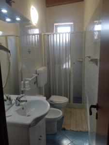 Un baño con lavabo, inodoro y ducha. en Residence Villa delle Rose, en Lampedusa 21 fotos más