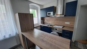 uma cozinha com armários azuis e um balcão de madeira em Fewo Böhle in Hainichen em Hainichen