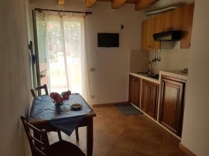 een kleine keuken met een tafel en een tafel en stoelen bij Residence Villa delle Rose in Lampedusa