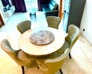 a wooden table with yellow chairs around it at Soho suite apartment hotel in Kuala Lumpur